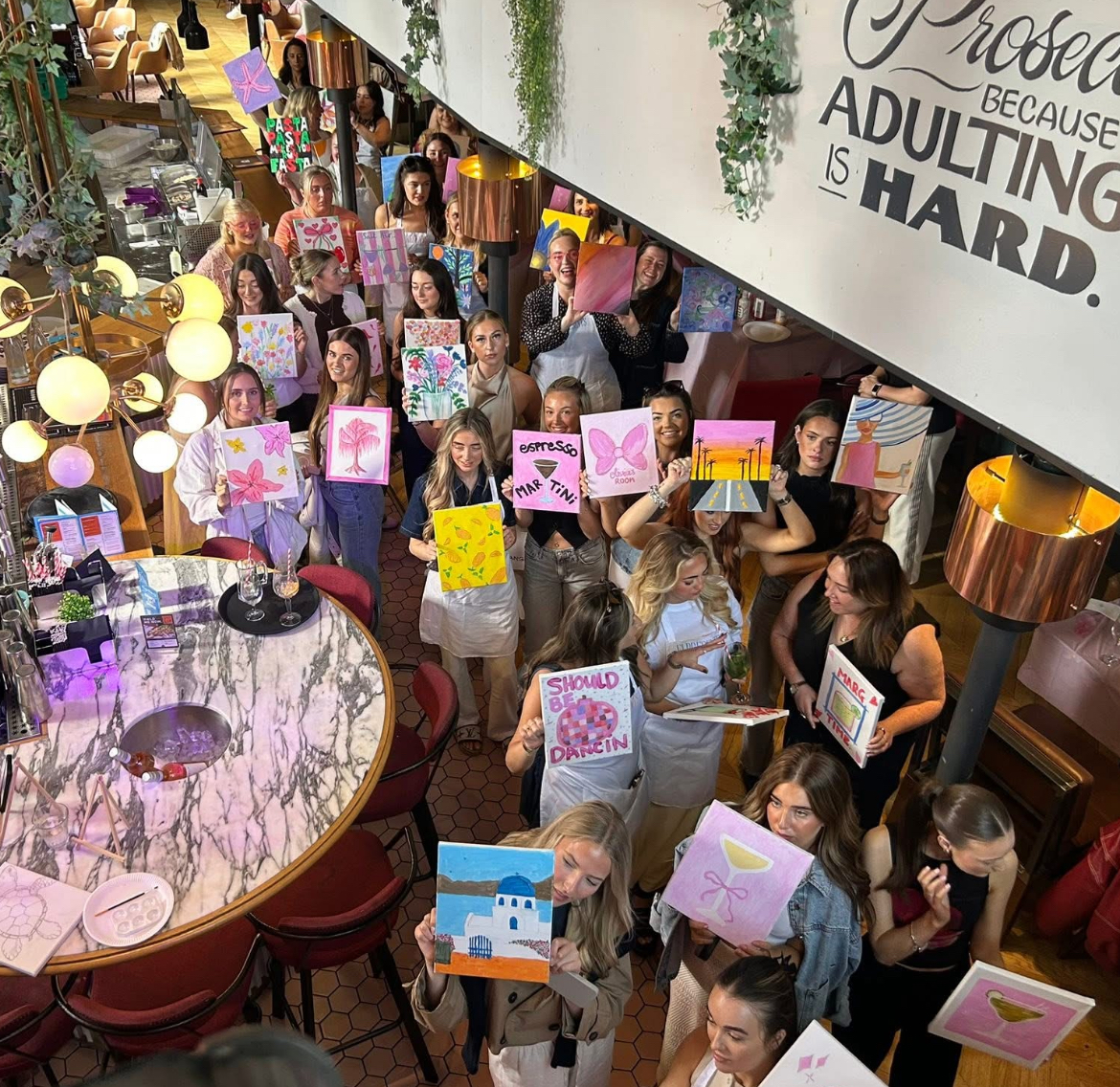 Attendees showing off their paintings at the Elpresents Sip and Paint Party
