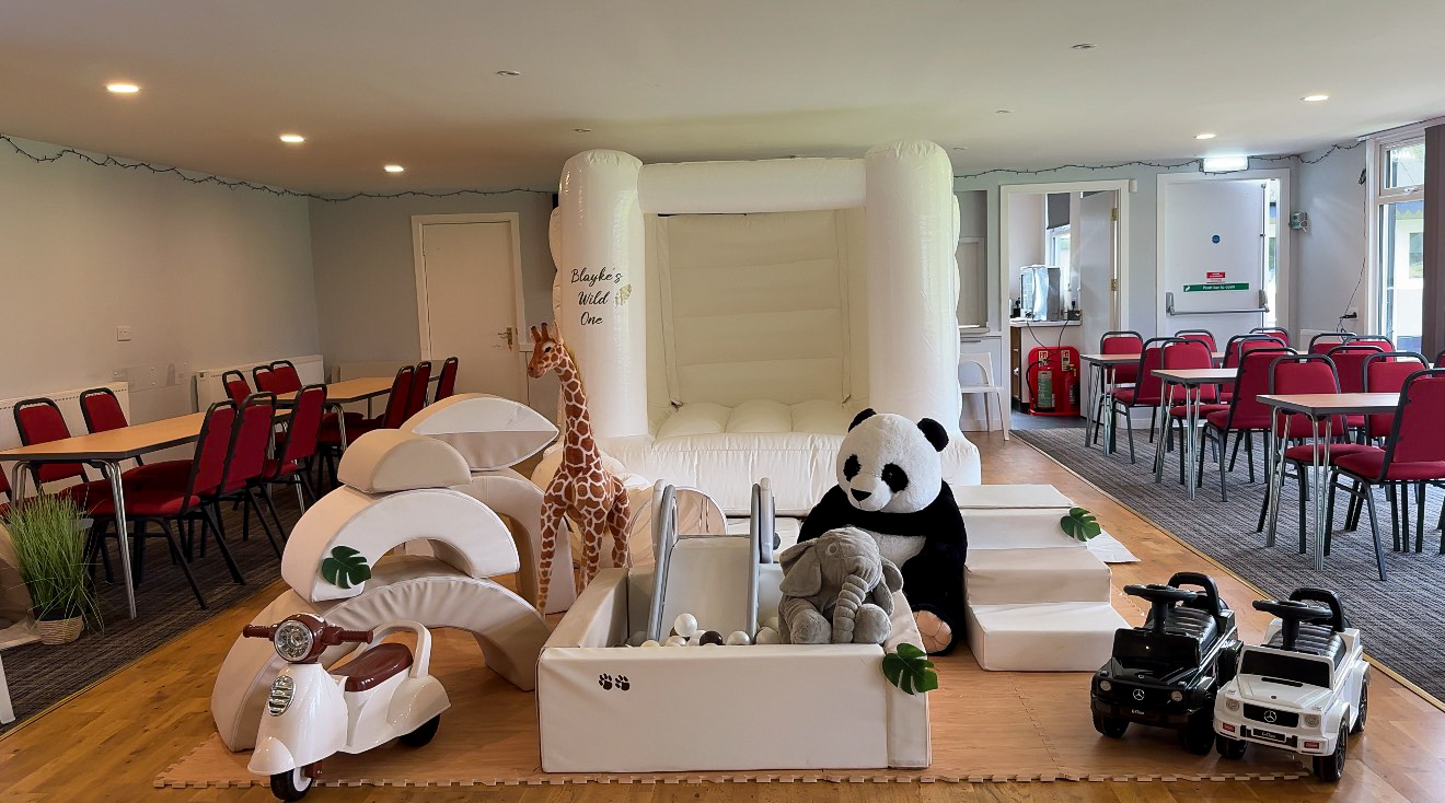 Full elpresents soft play setup - including a bouncy castle, ball pit with slide, stuffed animals, and ride-on moped and cars